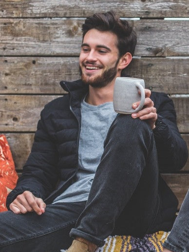 Young Man smiling and holding a Kava Beverage